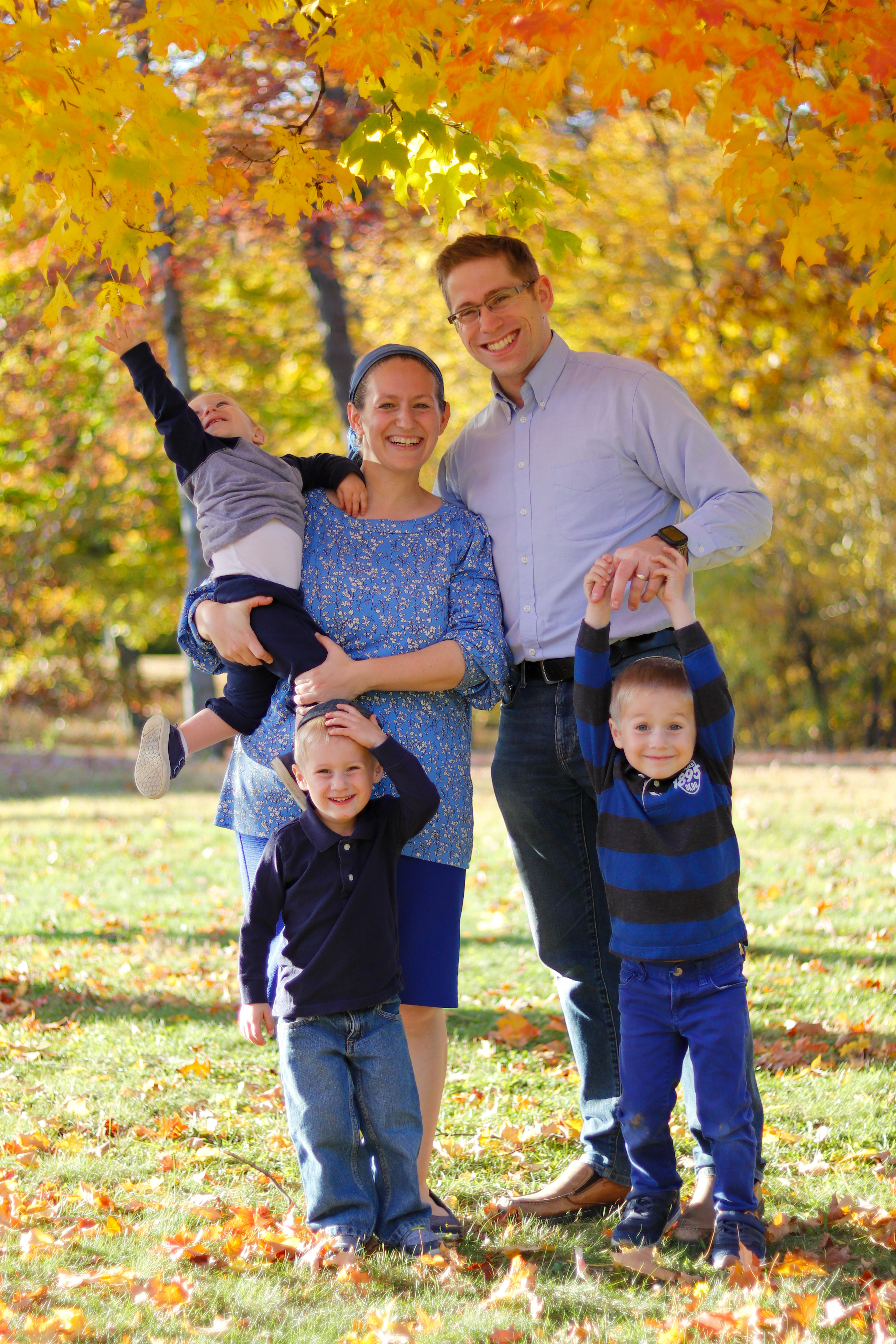 Family playing with leaves in Fall